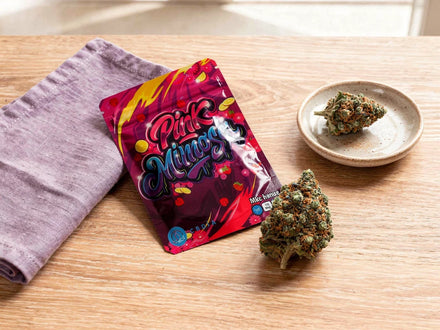 Cali Weed aus Nutzhanf: Pink Mimosa Pack mit Blüte auf hellem Holztisch